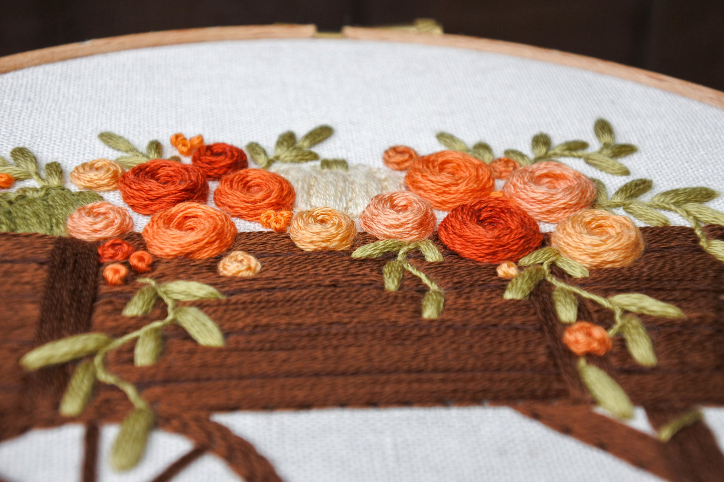 side view of 3D hand embroidered orange, red and peach roses