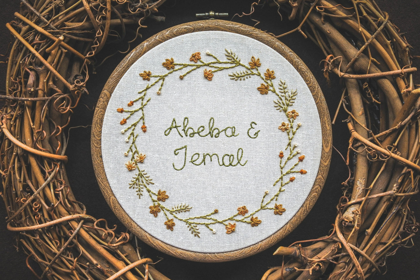 Hand-embroidered autumn wreath with personalised lettering ‘Abeba and Jemal’ in the centre