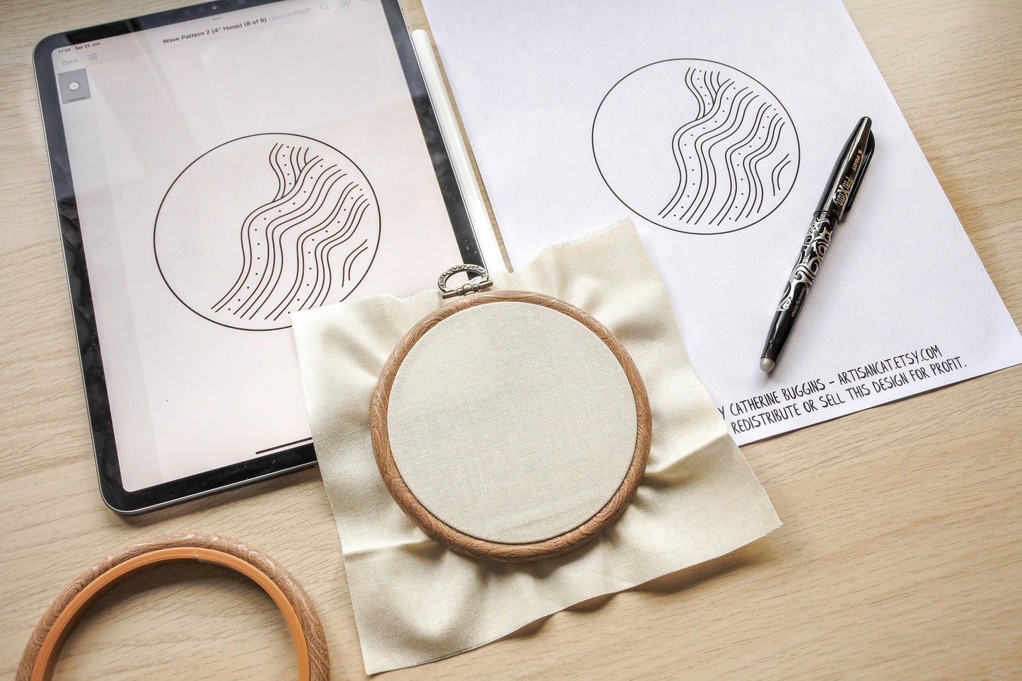 Beach wave embroidery pattern shown on an iPad with printed design and fabric in a wood effect hoop, demonstrating digital and physical tracing options