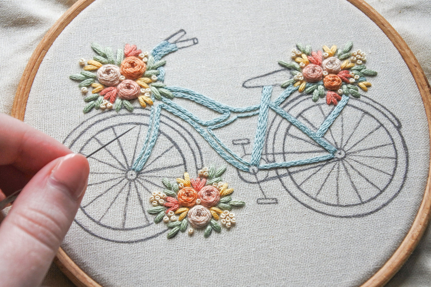 Photo of the floral bicycle design being stitched, showing details of the embroidery process.