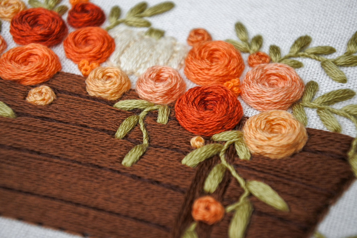 closeup of hand stitched rose details in the autumn wagon embroidery design
