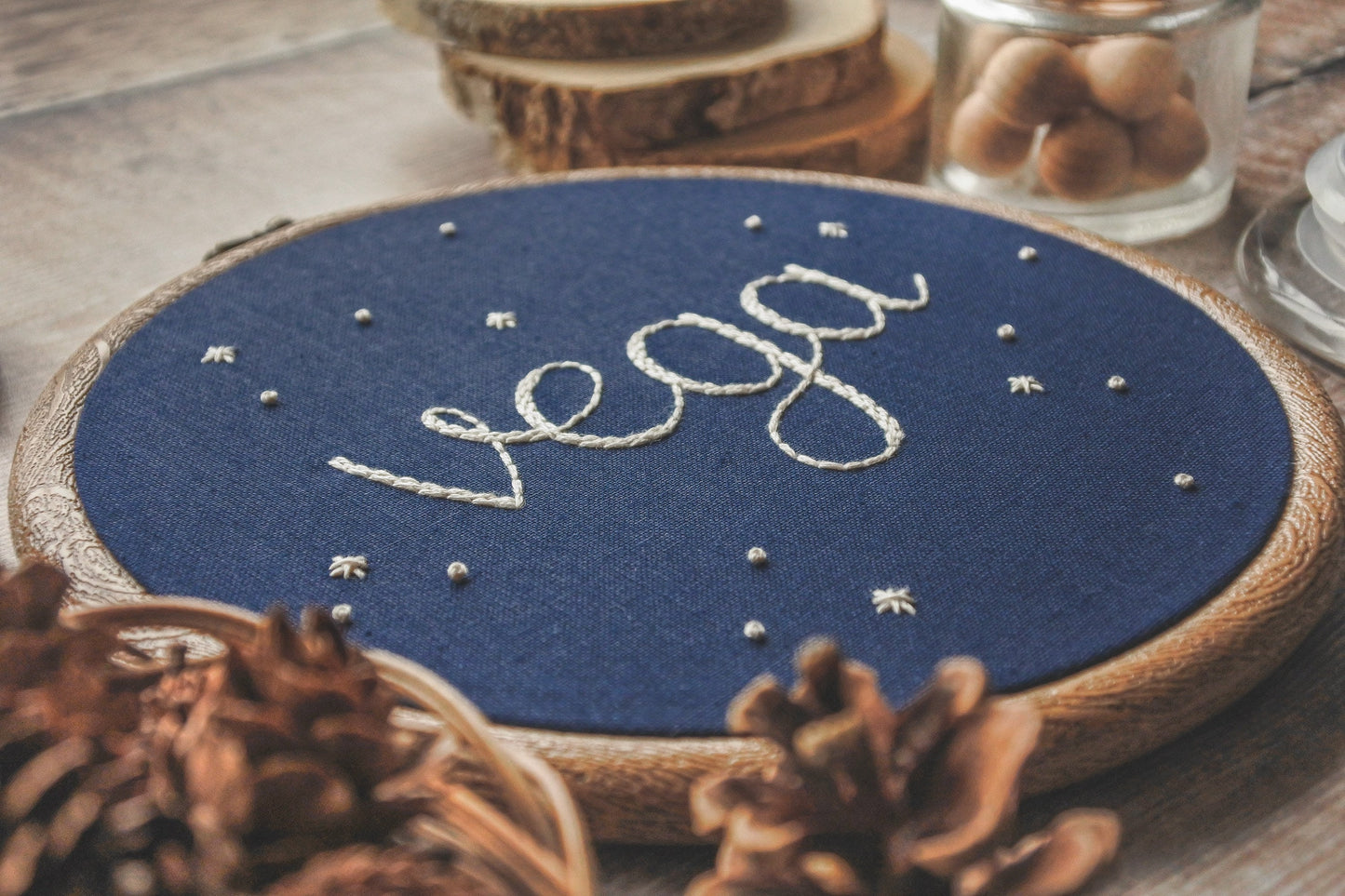 Starry name embroidery hoop with the name Vega, shown at an angle to highlight the texture of the stitching