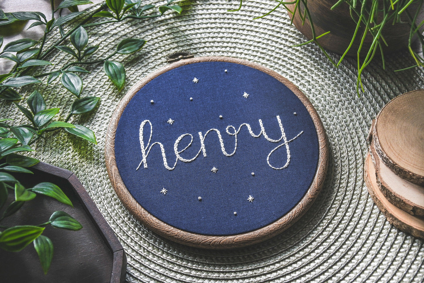 Starry name hoop featuring the name Henry, angled to show thread texture and star details