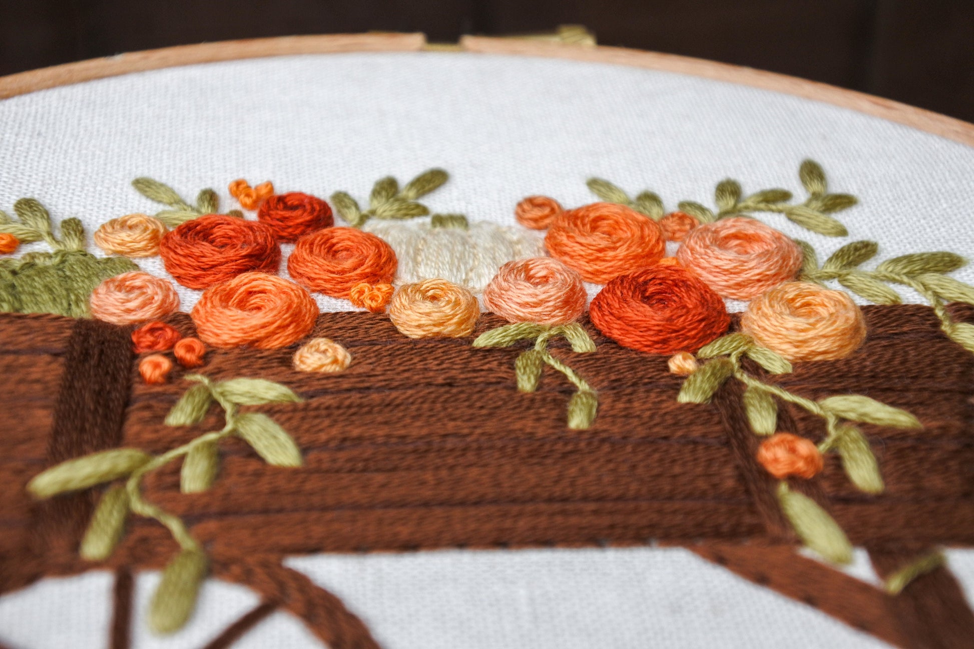 side view of 3D hand embroidered orange, red and peach roses