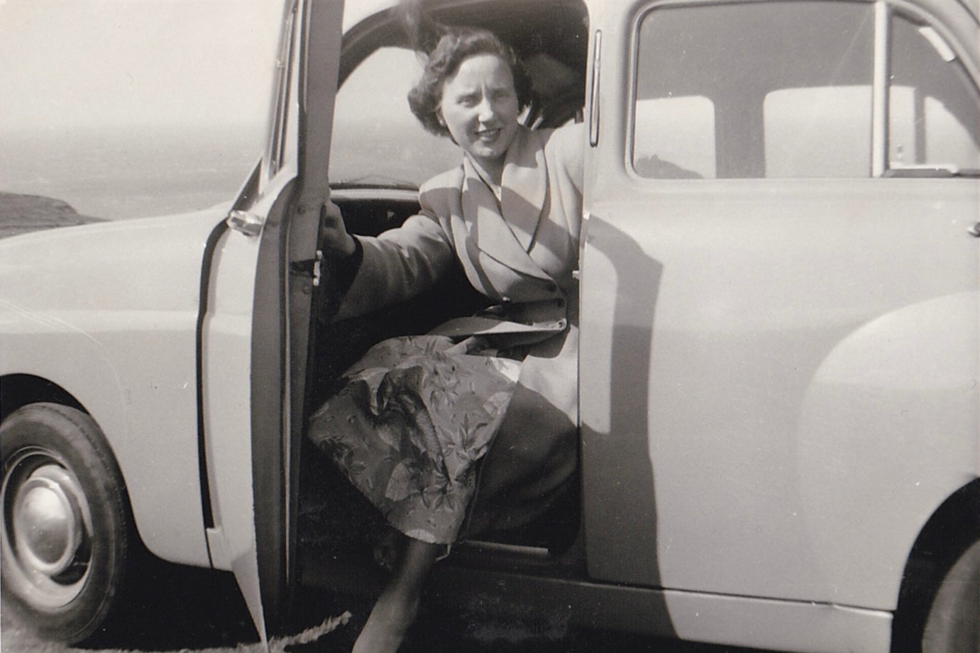 Old scanned photo of Catherine’s Nan posing while getting out of a car.