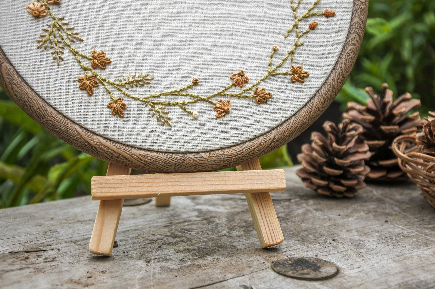 Close-up of personalised autumn wreath embroidery hoop on a wooden easel