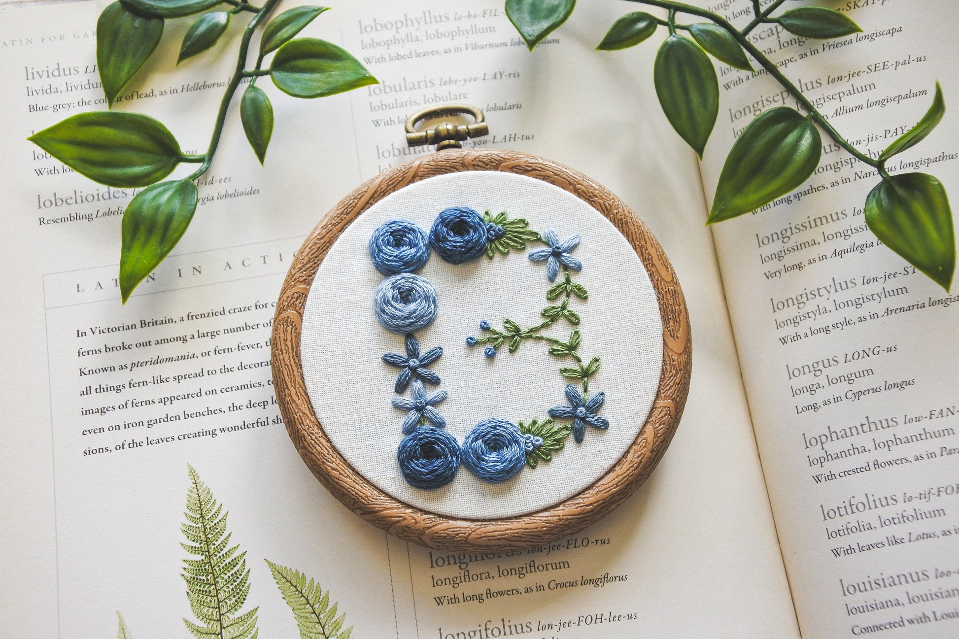 Blue floral letter 'B' embroidery hoop, highlighting the hand stitched flowers and detailing.