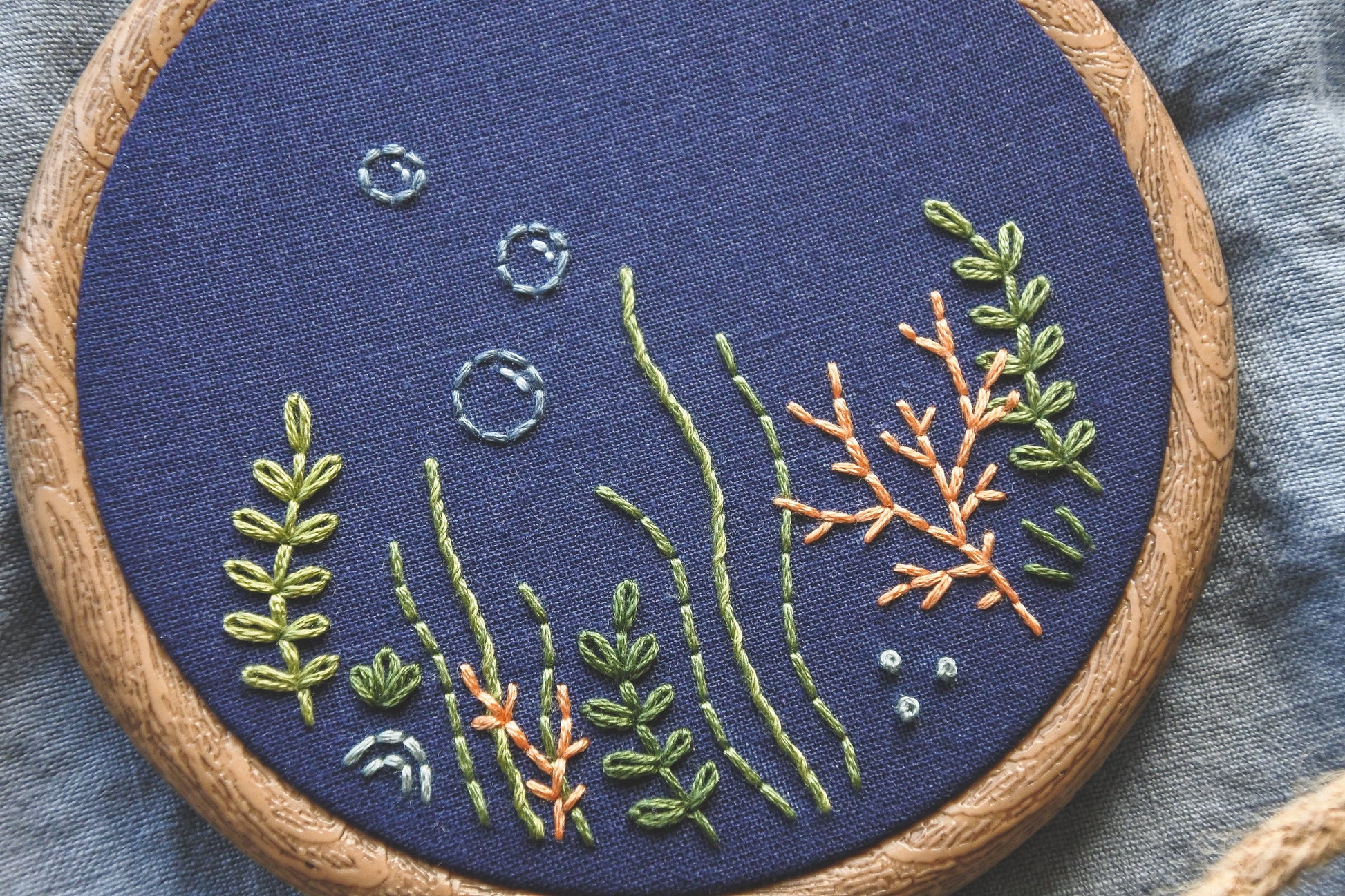 Closeup of coral reef embroidery design on navy blue fabric