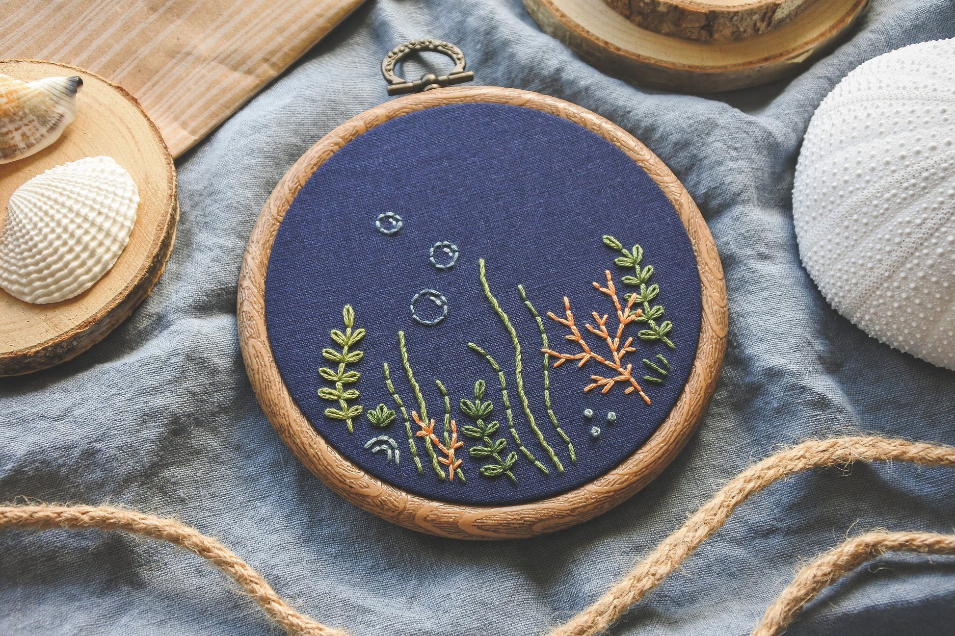 Hand embroidered coral reef design on navy blue fabric