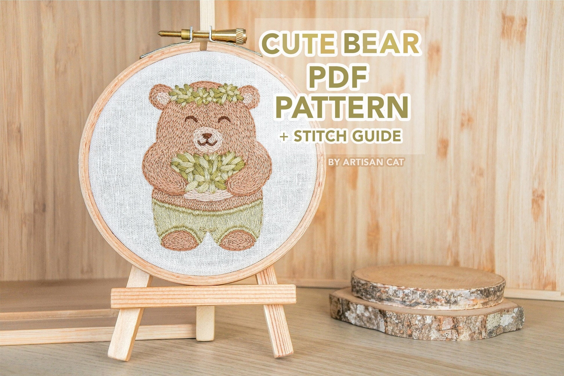 Hand-embroidered bear hoop on a mini wooden easel, with text overlay that reads “cute bear PDF pattern and stitch guide by artisan cat”