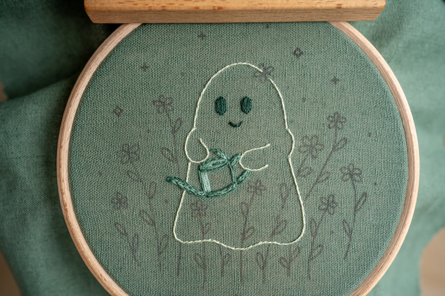hand embroidery work in progress of a happy ghost holding a watering can