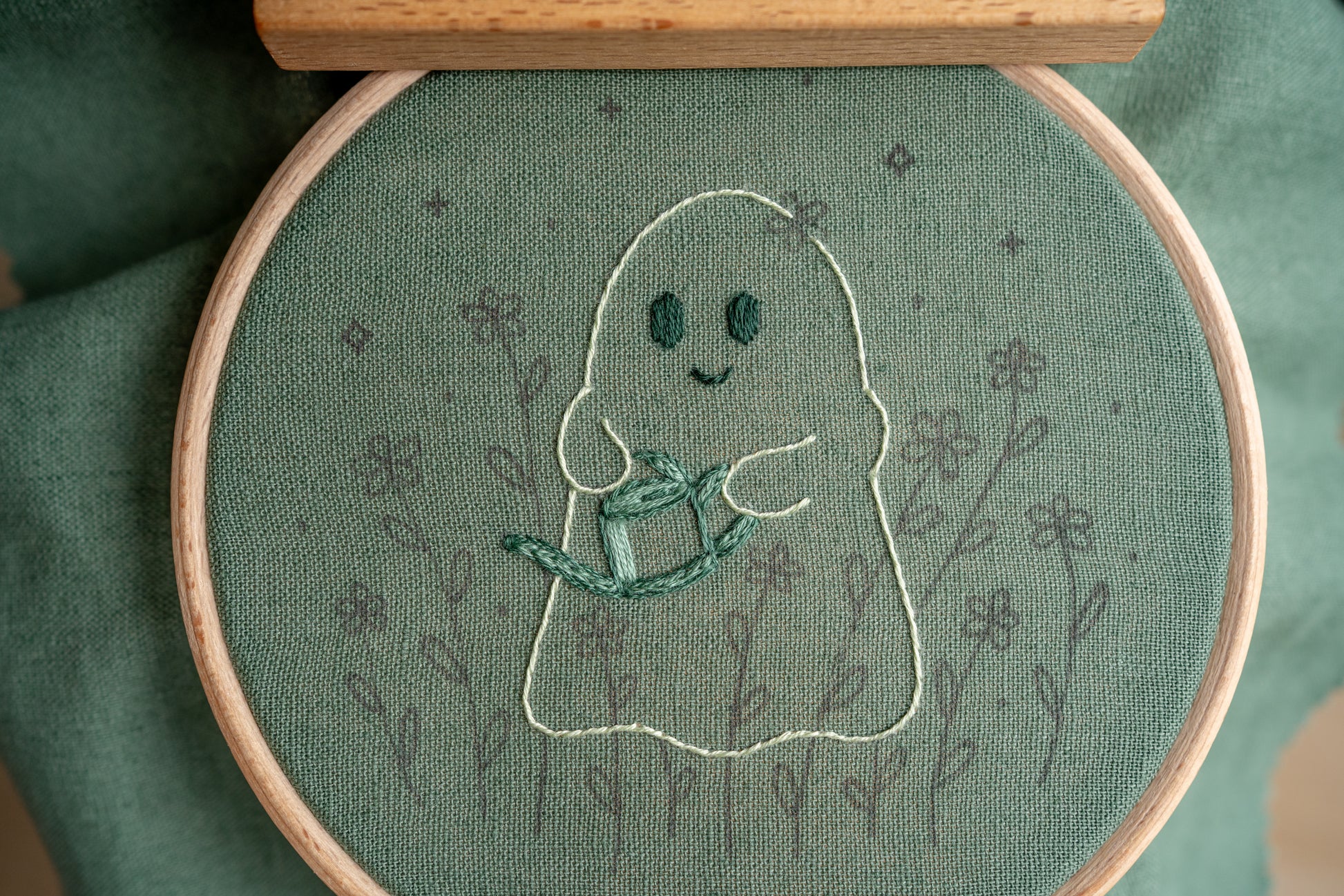 hand embroidery work in progress of a happy ghost holding a watering can