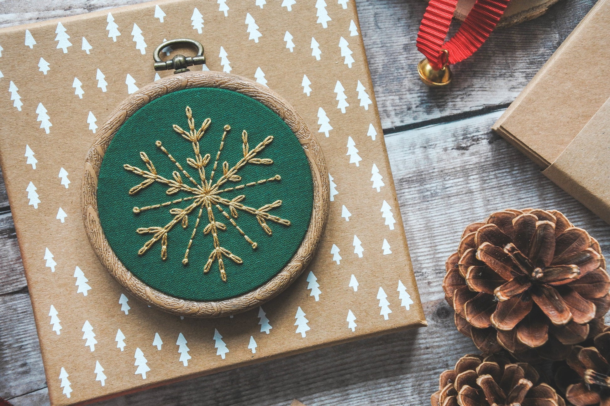 Gold snowflake on bottle green fabric in a 3-inch wood-effect hoop