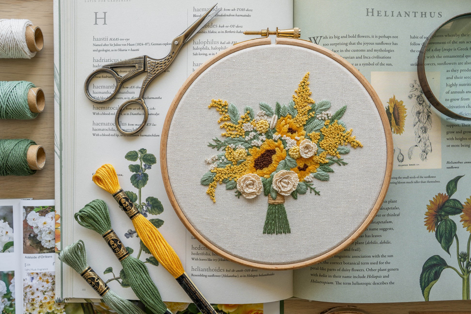 Hand-embroidered floral bouquet featuring sunflowers, cream roses and eucalyptus on neutral fabric in a wooden hoop frame