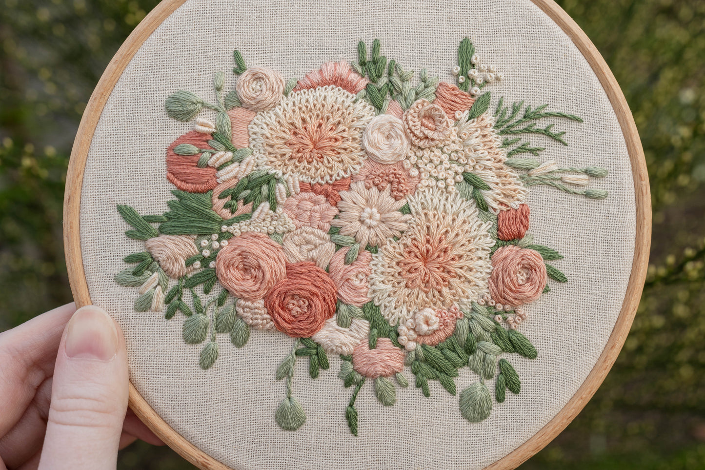 Closeup of detailed hand embroidered bridal bouquet, featuring dahlias and roses in soft pinks and creams, showcasing the different textures
