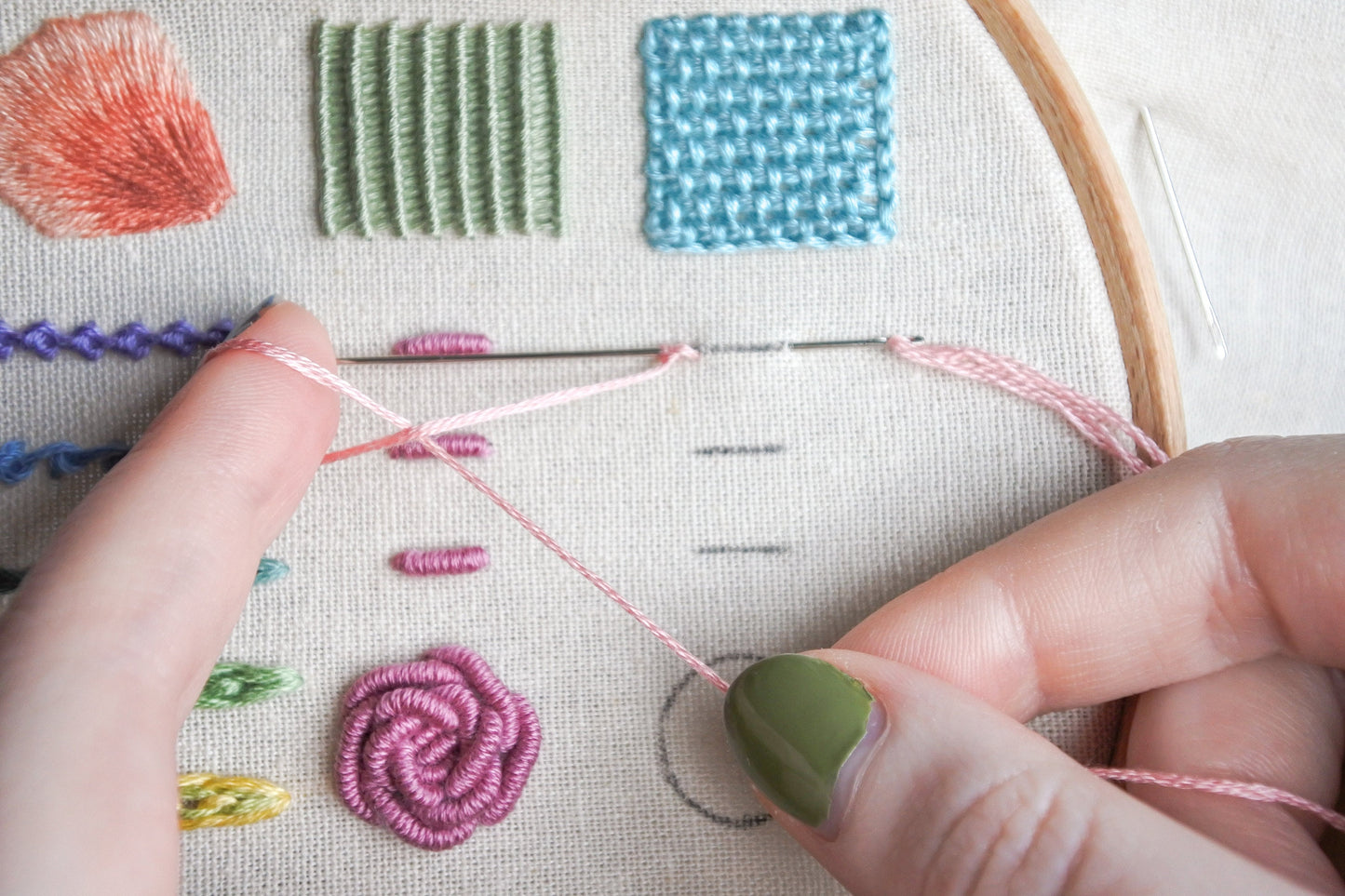 Hands looping light pink embroidery thread for cast-on stitch in progress on fabric