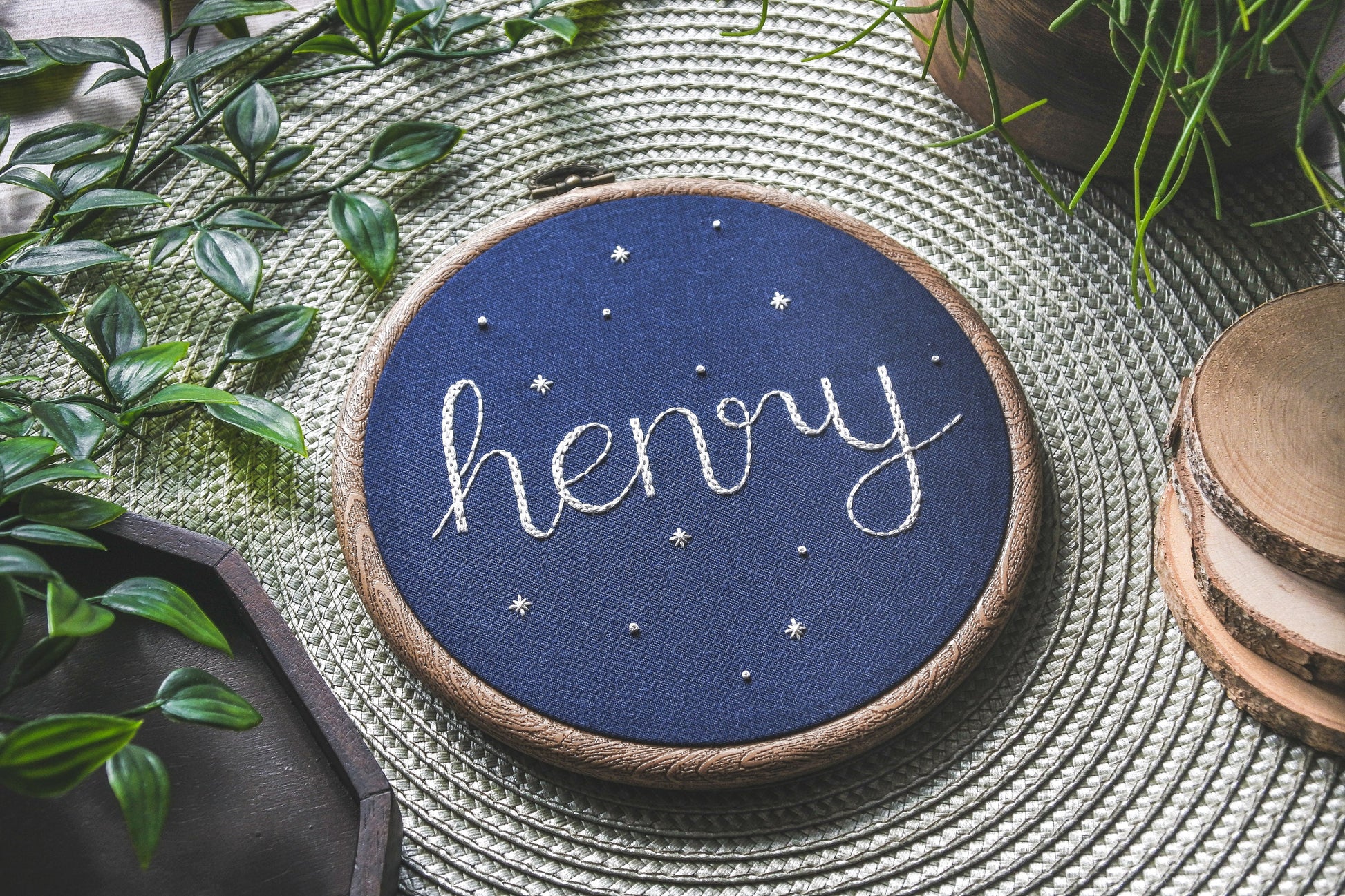 Starry name hoop featuring the name Henry, angled to show thread texture and star details