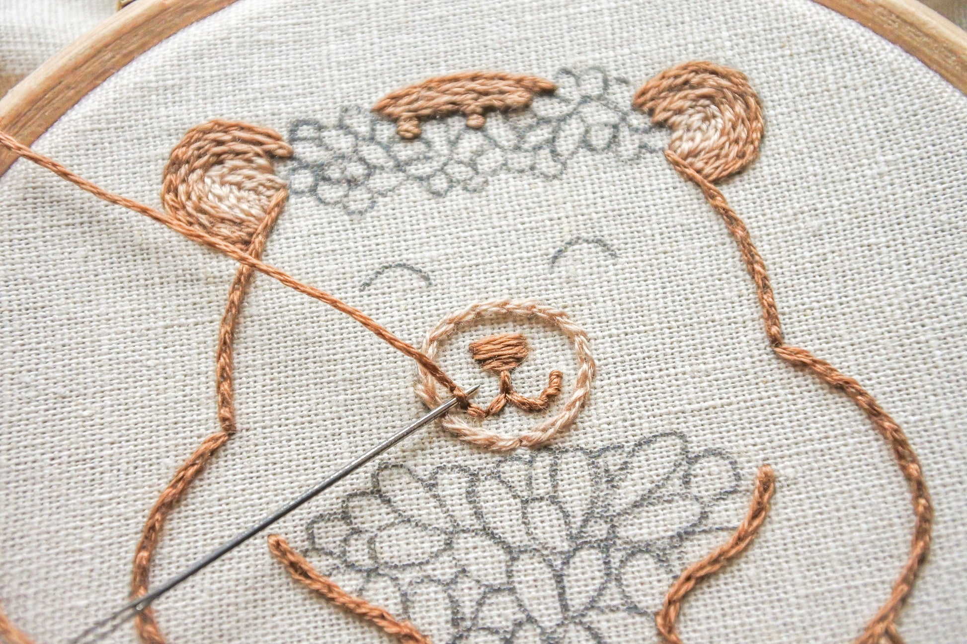 Close-up of stitching the bear’s happy face in the embroidery design.