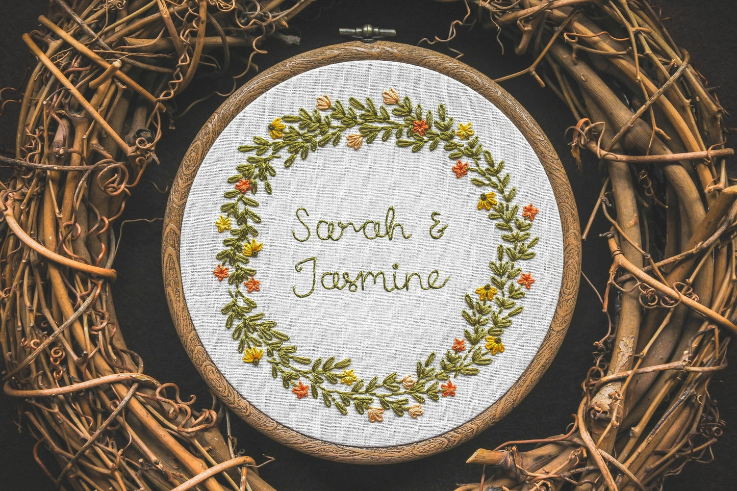 Embroidered hoop featuring “Sarah and Jasmine” surrounded by warm yellow and orange summer flowers