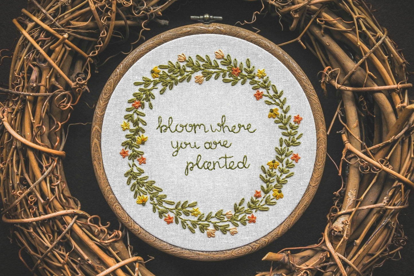 Summer wreath design with the quote "Bloom Where You Are Planted" embroidered in the centre.