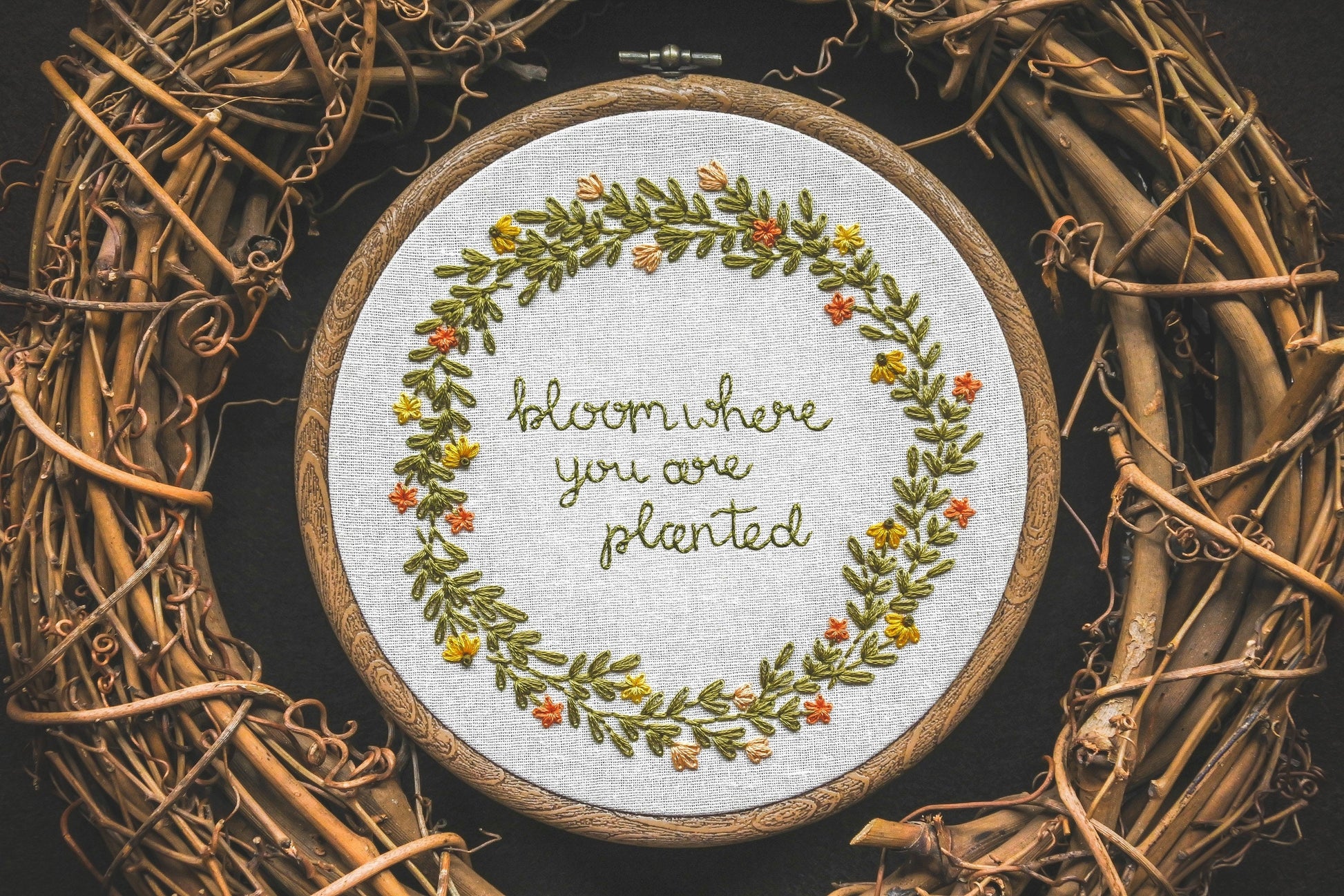 Summer wreath design with the quote "Bloom Where You Are Planted" embroidered in the centre.