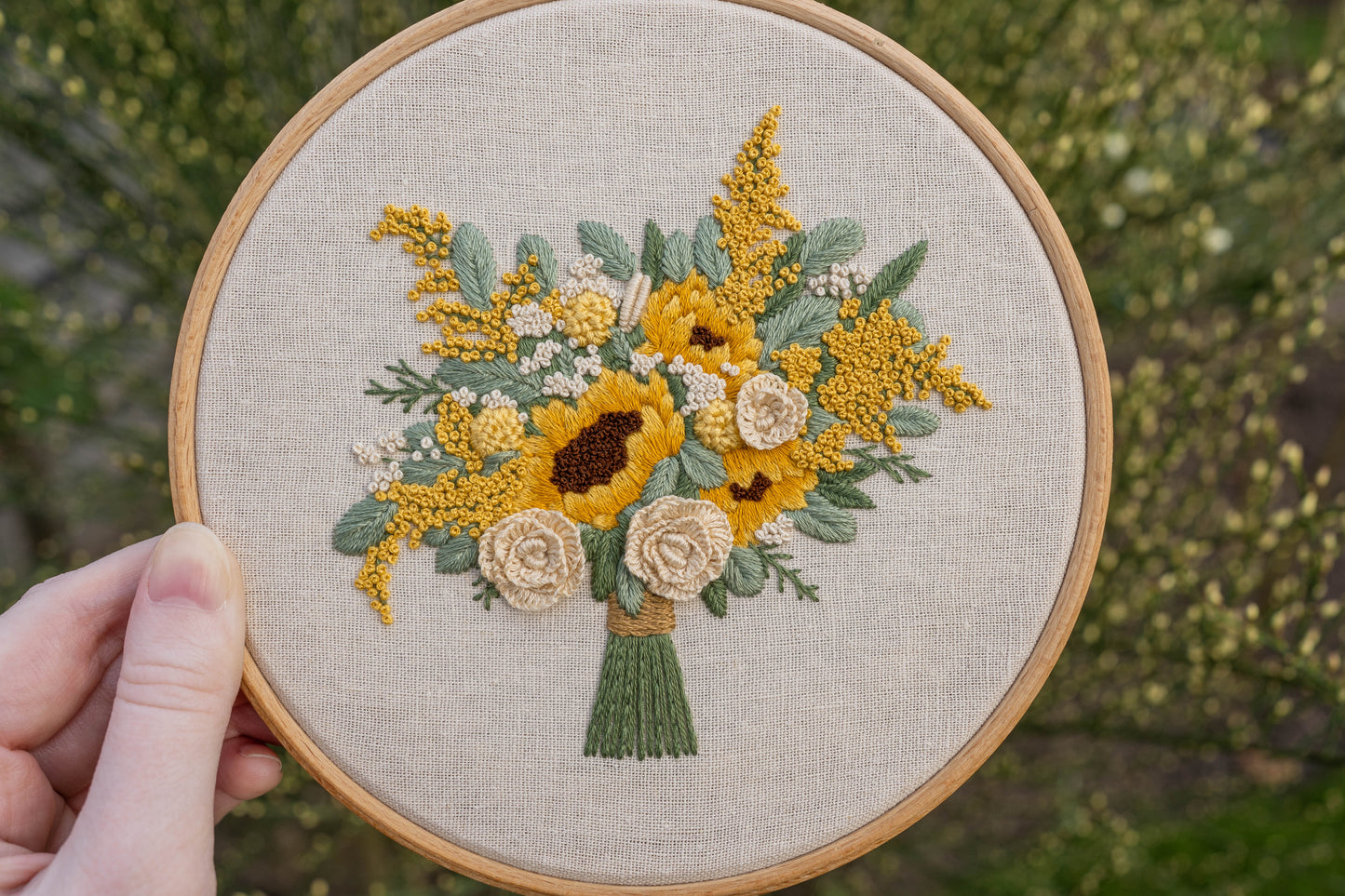 Detailed embroidery hoop featuring sunflowers and cream roses with soft green eucalyptus leaves
