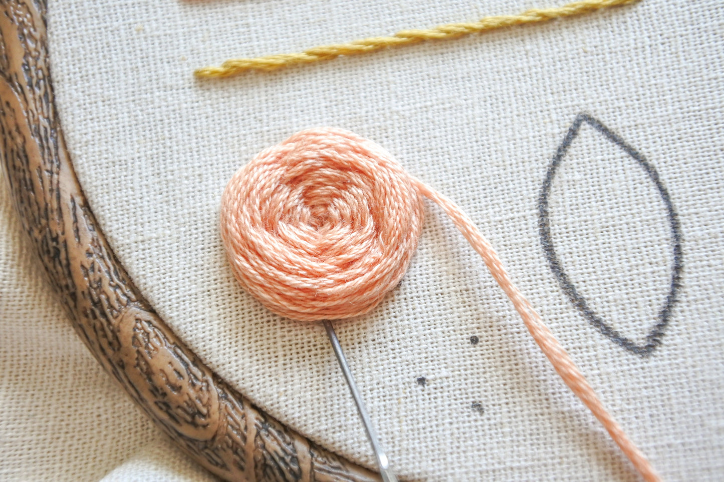 Peach rose being hand embroidered using woven wheel stitch.